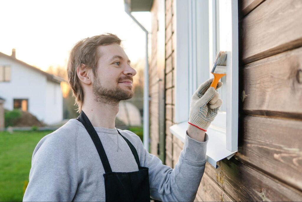 Man painting the outside of a home.