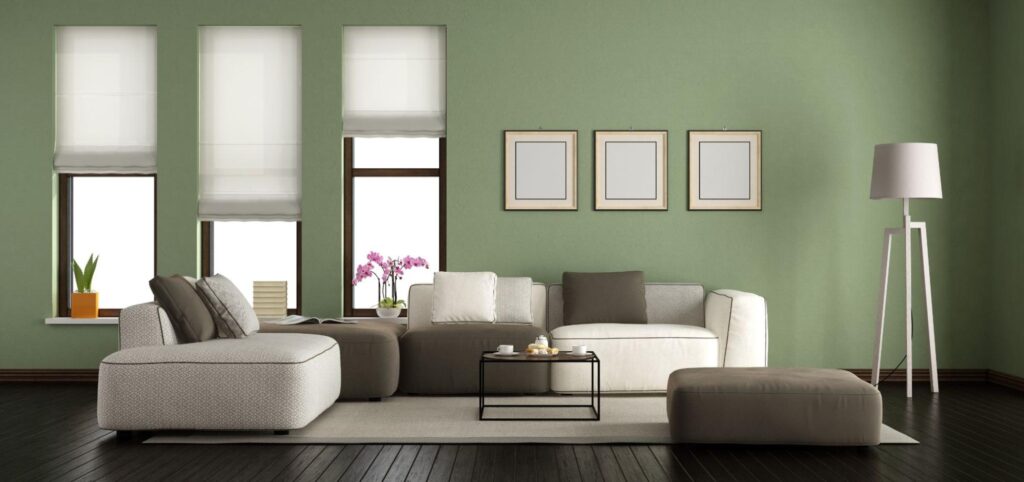 Chic living room with sage-green walls styled with white and gray furniture.